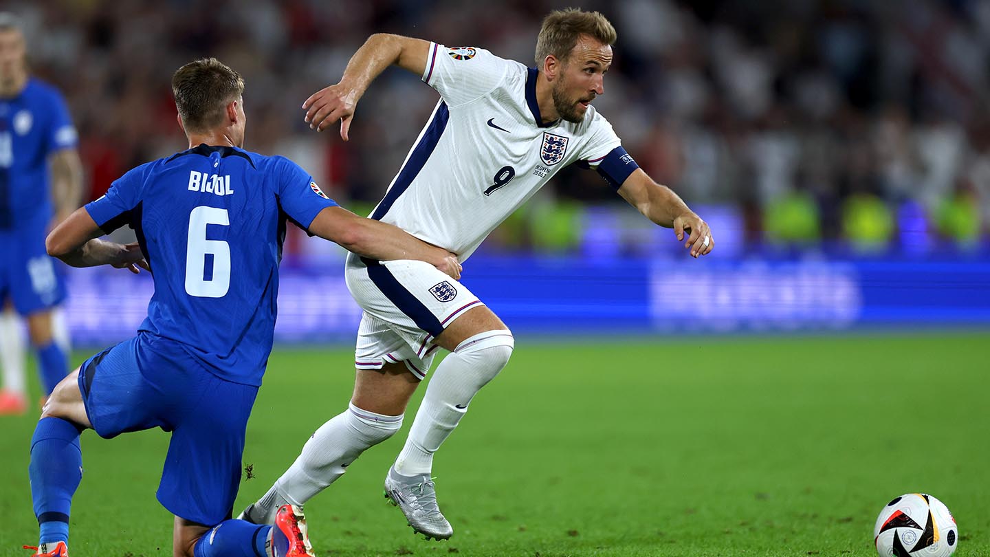 Harry Kane of England is held by Jaka Bijol of Slovenia during the UEFA EURO 2024 group stage match between England and Slovenia at Cologne Stadium
